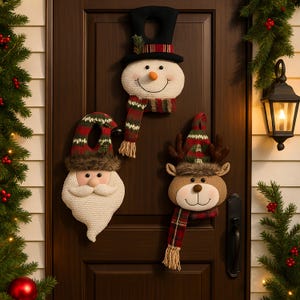 May include: Three festive door decorations: a snowman with a black top hat and scarf, Santa Claus with a red and green hat, and a reindeer with a matching hat and scarf. They are made of textured fabric and have smiling faces.