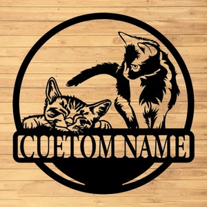 May include: Black metal silhouette of two cats, one sleeping and one standing, with the text "CUSTOM NAME" below.