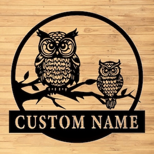 May include: Black metal silhouette of two owls perched on a branch, with the text "CUSTOM NAME" below.