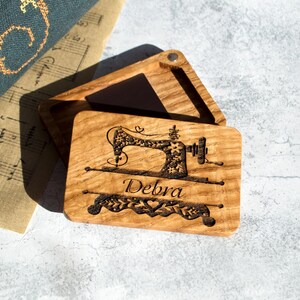 May include: A wooden box with a hinged lid, engraved with a sewing machine design and the name "Debra".