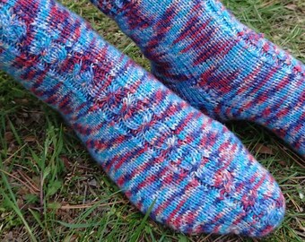May include: A pair of colorful knitted socks in shades of blue, red, and purple. The socks have a striped pattern and are made with a soft yarn.