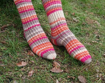 May include: A pair of striped socks in shades of brown, orange, and pink. The socks are knitted with a textured pattern and are worn on a person's feet.