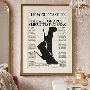 Peut inclure: Une impression encadr&eacute;e du journal "The Vogue Gazette" avec le titre "The Art of Arch: Silhouettes That Speak". L'image pr&eacute;sente une silhouette en noir et blanc de chaussures &agrave; talons hauts. L'impression est dans un cadre dor&eacute;, accroch&eacute;e &agrave; un mur rose.