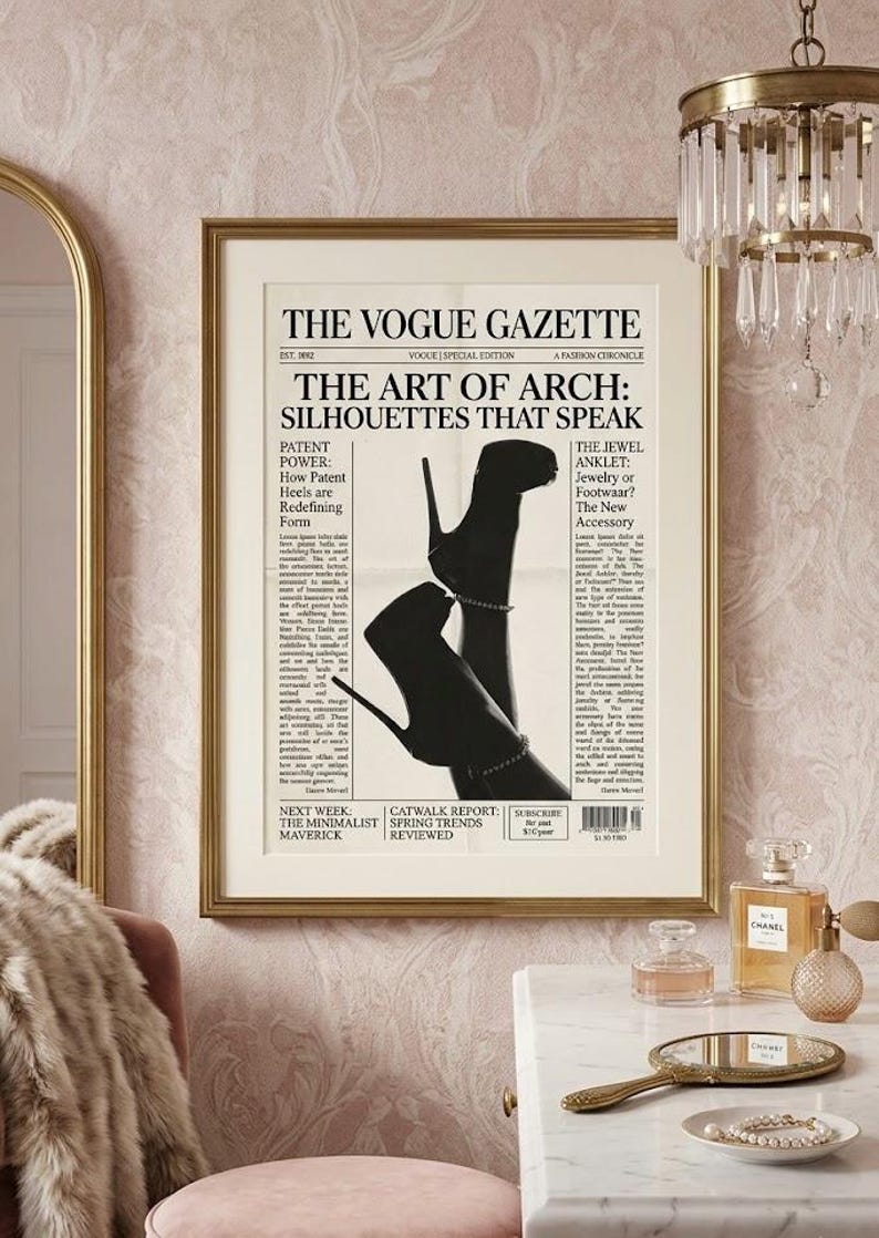 Peut inclure: Une impression encadr&eacute;e du journal "The Vogue Gazette" avec le titre "The Art of Arch: Silhouettes That Speak". L'image pr&eacute;sente une silhouette en noir et blanc de chaussures &agrave; talons hauts. L'impression est dans un cadre dor&eacute;, accroch&eacute;e &agrave; un mur rose.