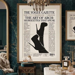 Peut inclure: Une impression encadr&eacute;e de Vogue Gazette avec le titre "The Art of Arch: Silhouettes That Speak" pr&eacute;sentant une image en noir et blanc de chaussures &agrave; talons hauts. La pi&egrave;ce a un lustre, une chaise et un comptoir en marbre.