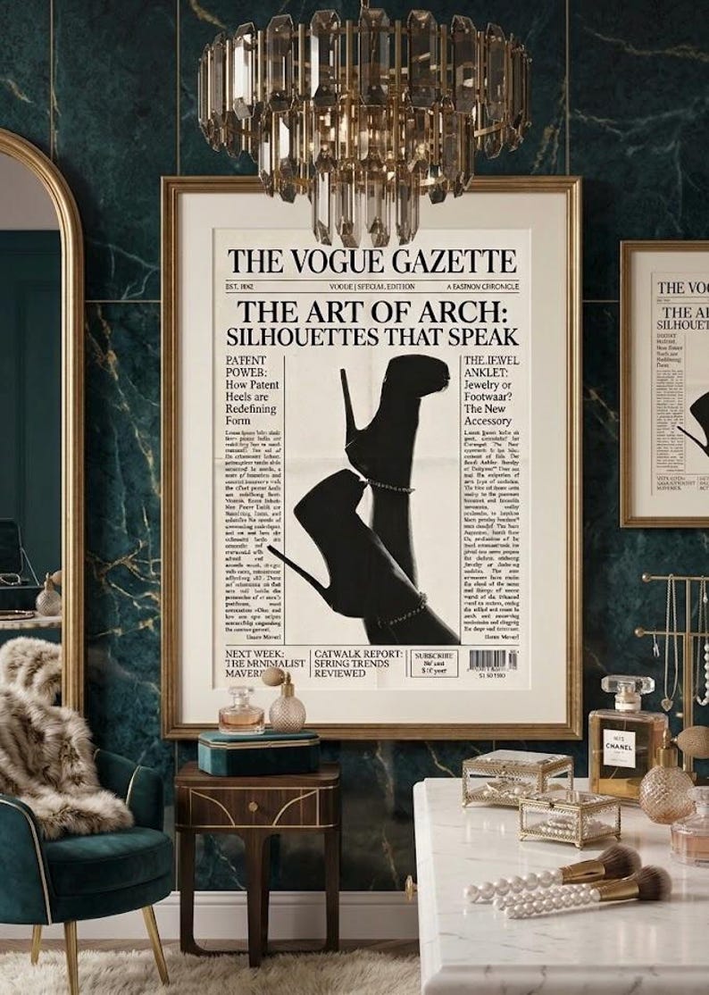 Peut inclure: Une impression encadr&eacute;e de Vogue Gazette avec le titre "The Art of Arch: Silhouettes That Speak" pr&eacute;sentant une image en noir et blanc de chaussures &agrave; talons hauts. La pi&egrave;ce a un lustre, une chaise et un comptoir en marbre.