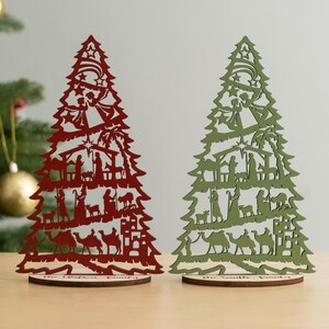 May include: Two wooden Christmas tree ornaments, one red and one green, with a nativity scene cutout design. The base of each tree reads "The Winter Family" and "The Spring Family".