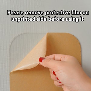 Puede incluir: Una l&aacute;mina acr&iacute;lica cuadrada y transparente con esquinas redondeadas. Una pel&iacute;cula protectora de color beige est&aacute; parcialmente despegada de la superficie. El texto Please remove protective film on unprinted side before using it aparece arriba.