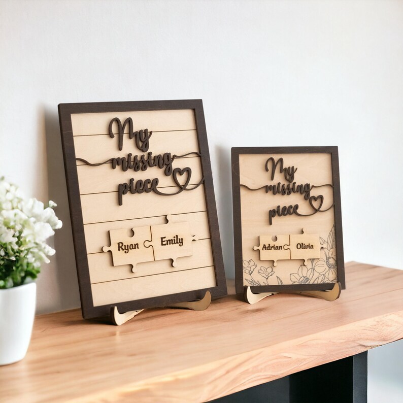 May include: Two wooden signs with the text "My missing piece" and a heart. The signs have two puzzle pieces with names on them. The names on the larger sign are Ryan and Emily. The names on the smaller sign are Adrian and Olivia.