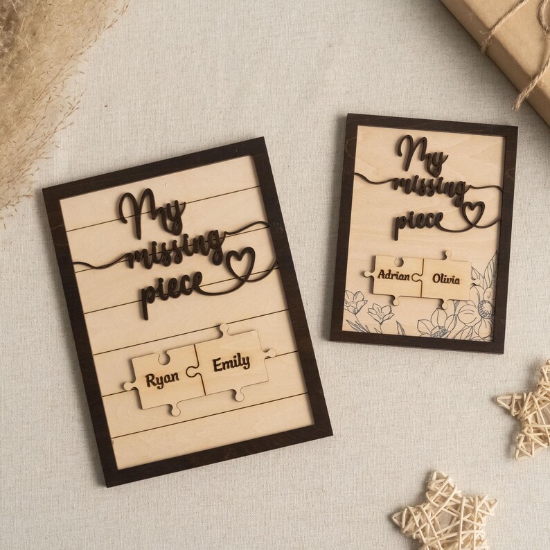 May include: Two wooden signs with the text "My missing piece" and a heart. Each sign has two puzzle pieces with names on them. The names on the signs are Ryan and Emily, and Adrian and Olivia.