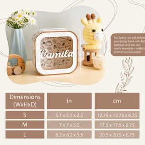 Puede incluir: Una hucha cuadrada de madera con un panel frontal transparente que muestra el nombre Camila en letra blanca sobre un fondo con estampado de dinosaurios. Una tabla indica las dimensiones en cm de 12,75 x 12,75 x 6,25 a 20,5 x 20,5 x 8,75 cm.