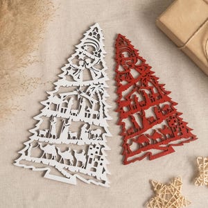 May include: Two wooden Christmas tree ornaments, one white and one red, with a nativity scene design. The ornaments are cut out and have a detailed design.