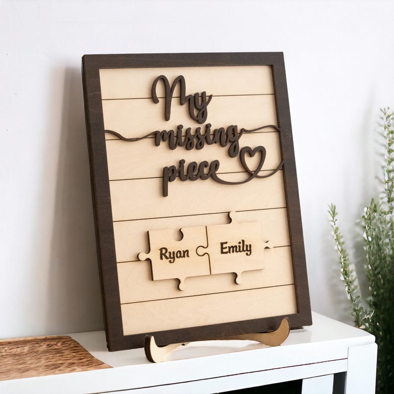 May include: Wooden sign with the text "My missing piece" and a heart, with two puzzle pieces below that say "Ryan" and "Emily".