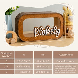 May include: Wooden piggy bank with a cutout window and the name "Blakely" written in white letters. The piggy bank is available in three sizes: small (17 x 10 x 6.5 cm), medium (23 x 13.5 x 9 cm), and large (28 x 16 x 10.5 cm).