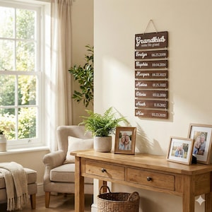 May include: A vertical wall hanging sign made of seven dark brown wooden planks connected by metal rings. The top plank reads "Grandkids make life grand" in white script. The six lower planks feature white names and dates: Evelyn 06.25.2009, Sophia 09.04.2014, Harper 08.22.2023, Mateo 01.25.2022, Olivia 03.12.2010, Noah 11.15.2012, and Mia 03.23.2020.