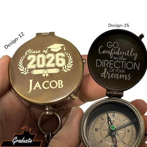 May include: Two brass compasses, one engraved with "Class of 2026" and "JACOB", the other with "GO Confidently in the DIRECTION of your dreams". Both compasses have a graduation theme, ideal for gifts.
