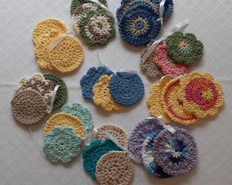May include: A collection of 12 crocheted coasters in various colours and patterns, including yellow, blue, green, pink, and purple. The coasters are arranged in a circle on a white surface.