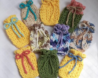 May include: Ten crocheted drawstring bags in various colours and patterns, including yellow, green, purple, and brown. The bags are all about the same size and have a small, tied bow at the top.