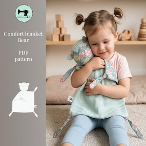 May include: A comfort blanket with a bear design, featuring a floral pattern on the bear's head and arms, and a mint green waffle-textured body. The text "Comfort blanket Bear PDF pattern" is visible.