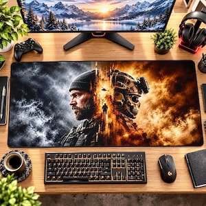 May include: A rectangular desk mat featuring a split-design graphic. The left side shows a bearded person in a beanie against a dark, smoky background. The right side depicts a tactical helmet with a skull motif amidst orange flames and debris.