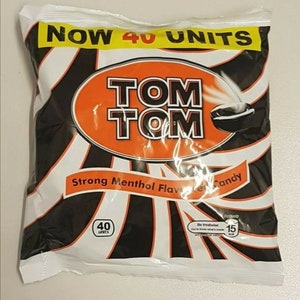 May include: A white bag with black and orange stripes. The bag contains Tom Tom Strong Menthol Flavored Candy. The bag says "NOW 40 UNITS" and "Be Treatwise".