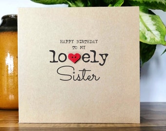 May include: A brown card with the text "Happy Birthday to my lovely Sister" with a red heart button in the middle of the word "lovely".