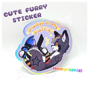 Puede incluir: Pegatina holográfica con un personaje de lobo de dibujos animados en azul, negro y naranja. La pegatina tiene el texto "Cute Furry Sticker" y "Always on my PUTER!" con detalles de estrellas. También se ve la palabra "Holographic!"