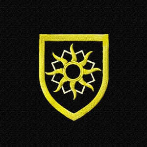 Puede incluir: Parche bordado con un diseño de sol amarillo dentro de un escudo. El sol tiene un círculo central y rayos radiantes. El escudo está delineado en amarillo sobre un fondo negro.