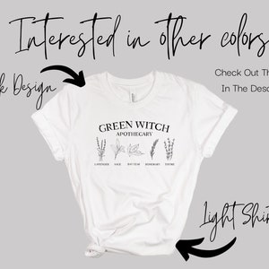 May include: White t-shirt with a black graphic that says "Green Witch Apothecary" with a drawing of herbs and their names: Lavender, Sage, Bay Leaf, Rosemary, Thyme. The text "Interested in other colors? Check Out The Listing In The Description" is above the shirt and the text "Dark Design" and "Light Shirt" are on either side of the shirt.