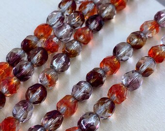 May include: A strand of faceted glass beads in shades of orange, purple, and silver. The beads have a shimmery, iridescent finish.