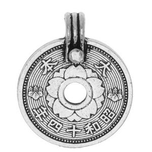 May include: A silver-colored pendant with a circular coin design. The coin features a central floral pattern with a hole in the middle, surrounded by Japanese characters. The pendant has a loop at the top for a chain.