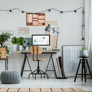 May include: A home office workspace with a computer, desk, chair, and plants. A poster with the Adobe Illustrator logo is hanging on the wall.