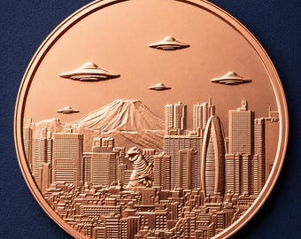 May include: A circular copper-toned coin featuring a relief design of a city skyline with a large mountain in the background. A creature stands among the buildings, while several disc-shaped flying objects are positioned in the sky above.