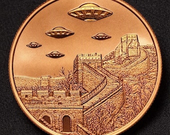 May include: A round copper-toned commemorative coin featuring a detailed relief of the Great Wall of China winding through a landscape with bare trees. Above the wall, four flying saucer-shaped objects are depicted in the sky in a line.