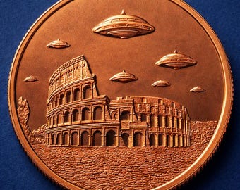 May include: A round copper-toned coin featuring a detailed relief of the Roman Colosseum. Above the structure, six flying saucer-shaped objects are depicted in the sky. The surface of the coin has a textured, metallic finish with raised edges.