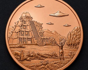 May include: A round copper-colored coin featuring a relief design of a stepped pyramid structure near a body of water. A figure stands with arms raised toward four flying saucer-shaped objects in the sky above a landscape with trees and plants.