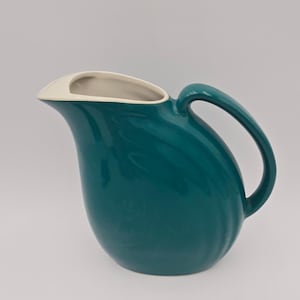 May include: A set of three ceramic mugs with a speckled, matte finish. The mugs are in shades of cream, light gray, and dark gray. Each mug has a simple, minimalist design and a rounded handle.