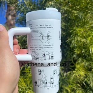 Könnte beinhalten: Ein weißer Edelstahlbecher mit einer schwarz-weißen Comic-Illustration einer Figur aus der Buchreihe Tagebuch eines Wimpy Kids. Der Becher hat einen Griff und einen Deckel. Der Text auf dem Becher lautet "Wednesday" und "If I said something then I would then have the time touch! And I certainly didn't want that... I kept my mouth shut."