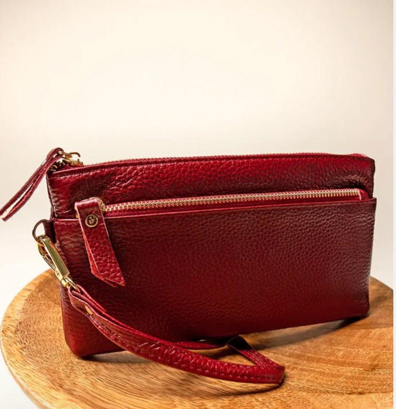 Genuine Leather Construction
Zip Top Closure
Fully Lined
Zip and Open Pockets
Center Zip Dividing Pocket
Outside Zip Pocket
Removable Wrist Strap
7.5" Wide x 3.75" Tall x .5" Deep