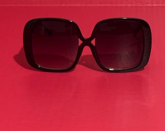 Puede incluir: Gafas de sol cuadradas negras con lentes oscuros.