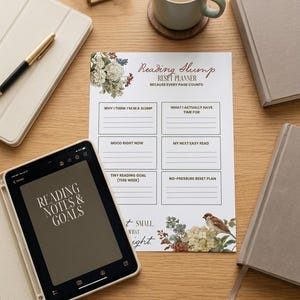 Pode incluir: Cena de mesa com um planejador "Reading Slump Reset Planner" e um tablet exibindo "Reading Notes & Goals". Uma xícara de café, livros e uma caneta também estão na superfície de madeira.