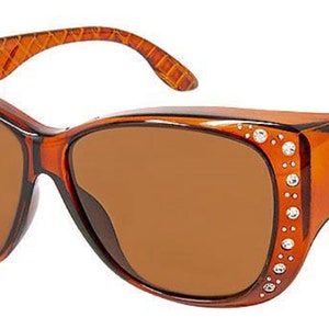 May include: Brown tortoise shell sunglasses with brown lenses and rhinestones on the sides. The sunglasses have a textured pattern on the arms.