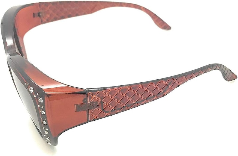 May include: Brown plastic sunglasses with a diamond-shaped pattern on the arms and rhinestones around the lenses.