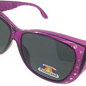 May include: Purple sunglasses with rhinestones around the lenses and a "Polarized" label on the side.