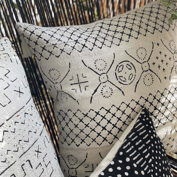 Coussin Motif imprimé écru et noir - en coton 100 % biologique tissé et imprimé à la main avec des pompons dans les coins