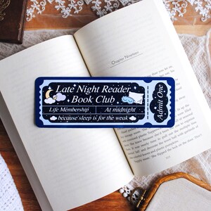 May include: A rectangular dark blue bookmark shaped like an admission ticket featuring a crescent moon, clouds, a pillow, and an eye mask. The text reads Late Night Reader Book Club, Life Membership, At midnight, because sleep is for the weak, and Admit One.