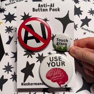 May include: A set of three round buttons on a white card with black star patterns. One button is red and white with a black 'No AI' symbol. Another is white with green grass and the text 'Touch grass'. The third is white with a pink brain and 'USE YOUR'.