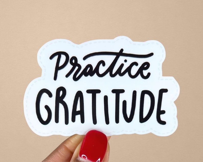Puede incluir: Pegatina blanca con texto negro que dice "Practica la gratitud".