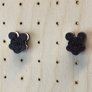 K&ouml;nnte beinhalten: Zwei Ohrringe aus Holz in Form von Mickey Mouse Kopf. Die Ohrringe sind schwarz und wei&szlig; bemalt, um einem Oreo-Keks zu &auml;hneln.