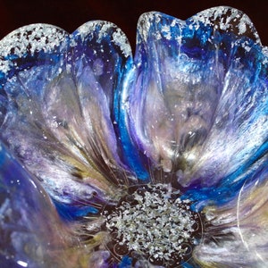 May include: A blue and purple resin flower bowl with silver glitter accents. The bowl is shaped like a flower with multiple petals.